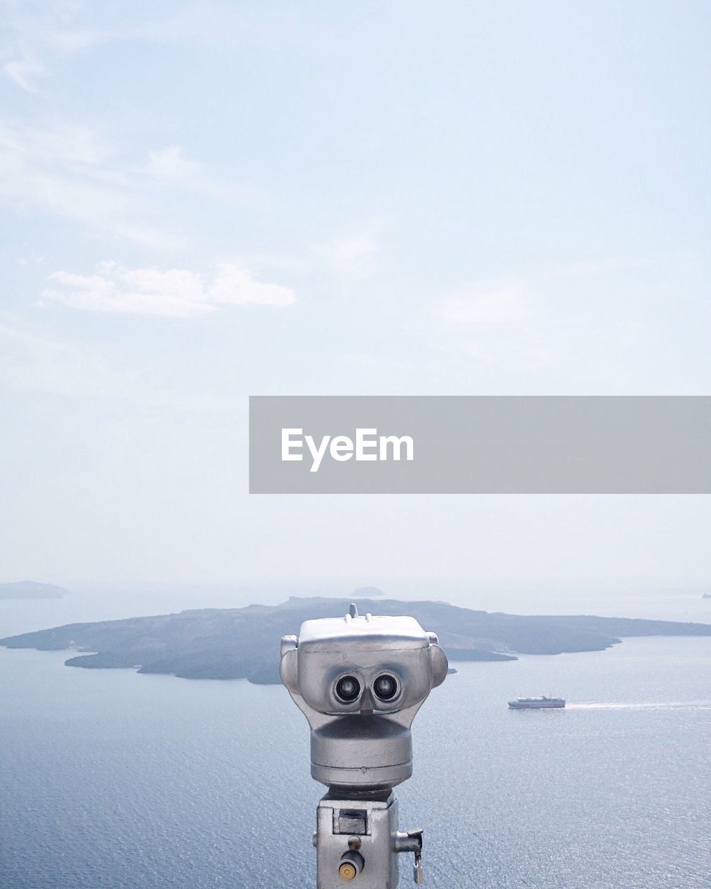 CLOSE-UP OF COIN-OPERATED BINOCULARS AGAINST CITYSCAPE