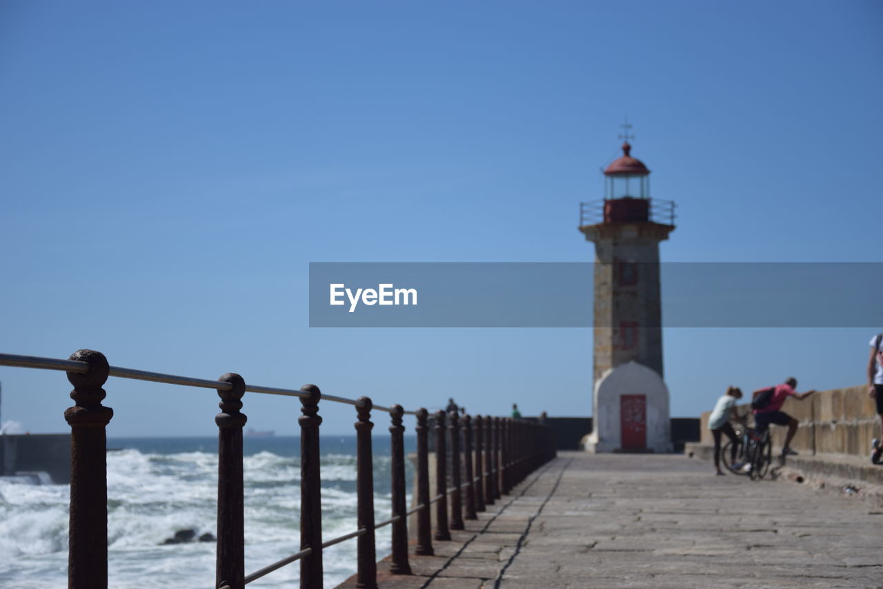 LIGHTHOUSE BY SEA AGAINST SKY