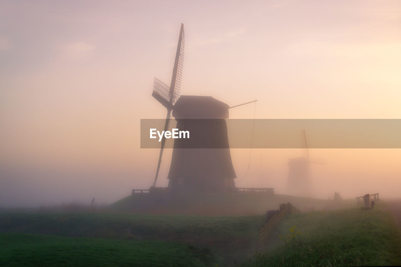 TRADITIONAL WINDMILL ON FIELD DURING SUNSET