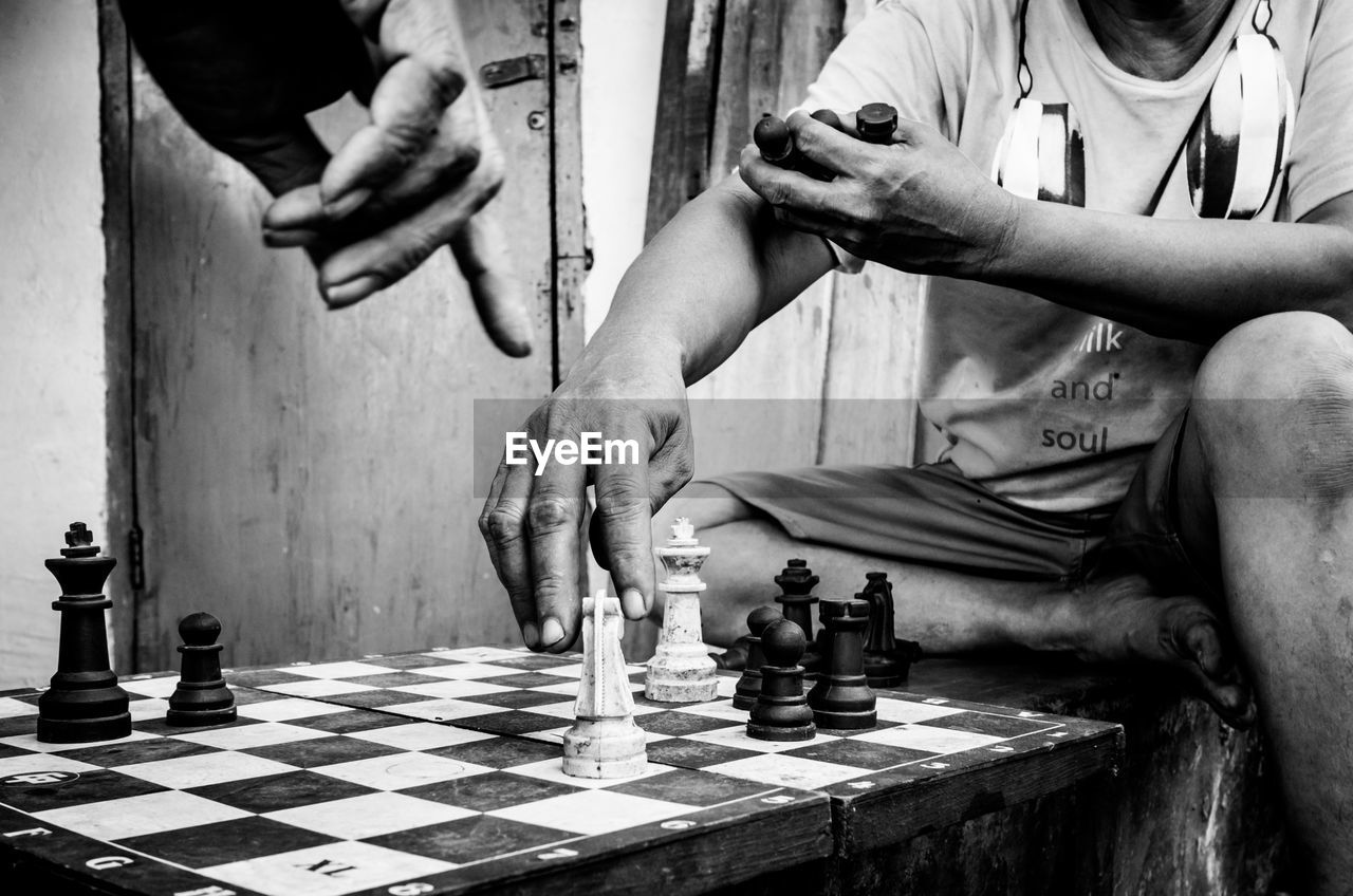 Close-up of men playing chess outdoors