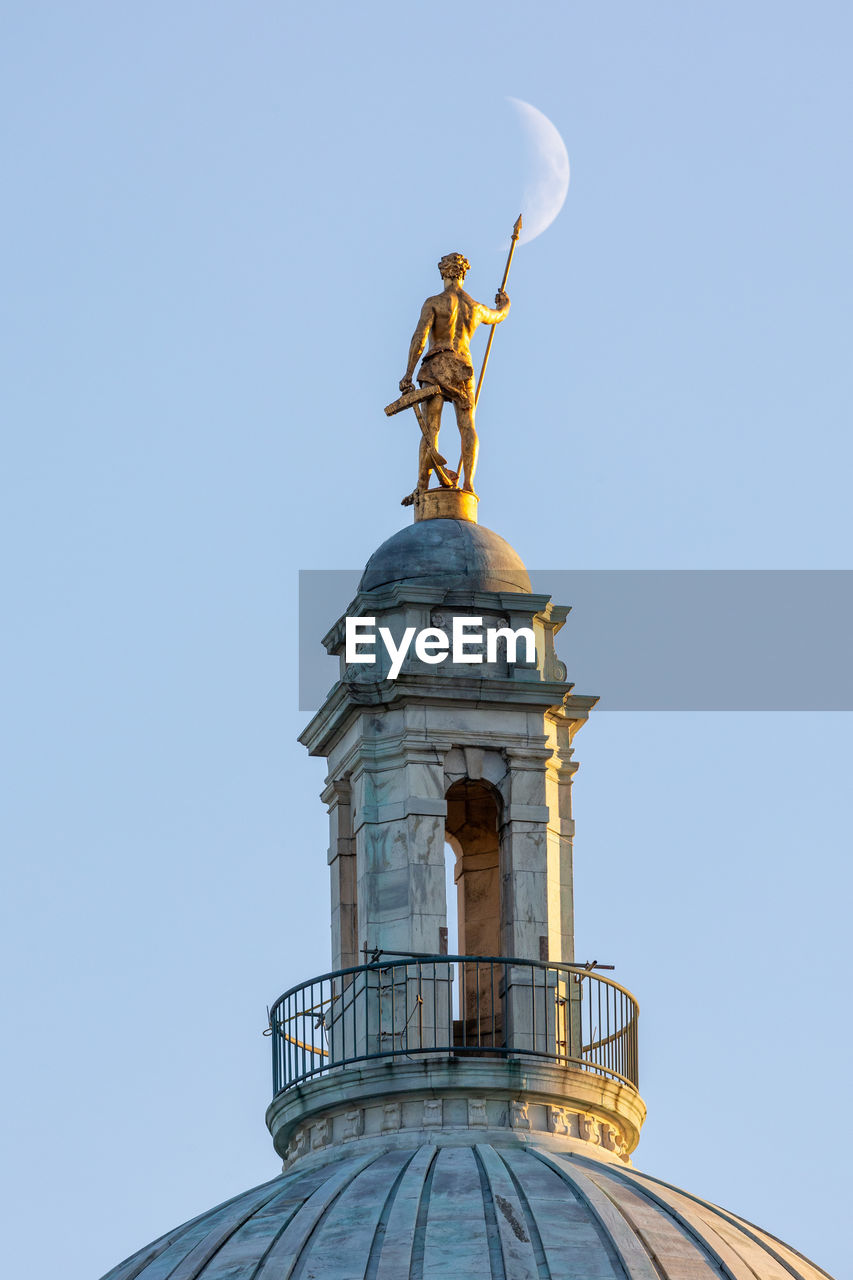 Statue on the top of the rhode island capitol building with the moon