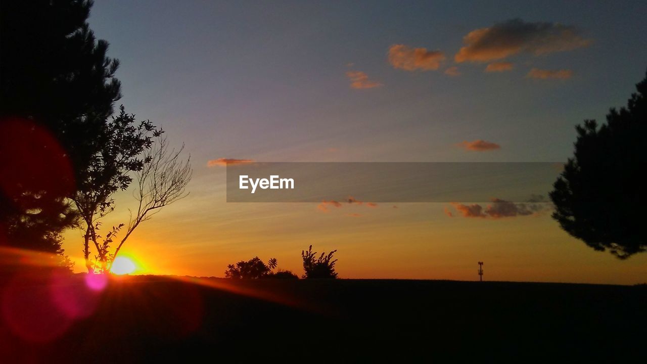 SCENIC VIEW OF SILHOUETTE FIELD AGAINST SKY DURING SUNSET