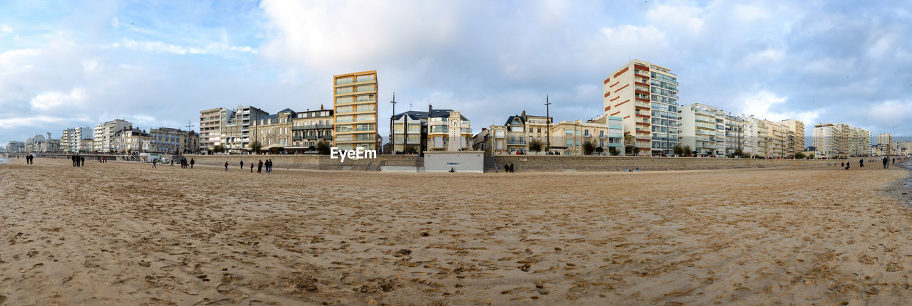 PANORAMIC VIEW OF BEACH AGAINST BUILDINGS