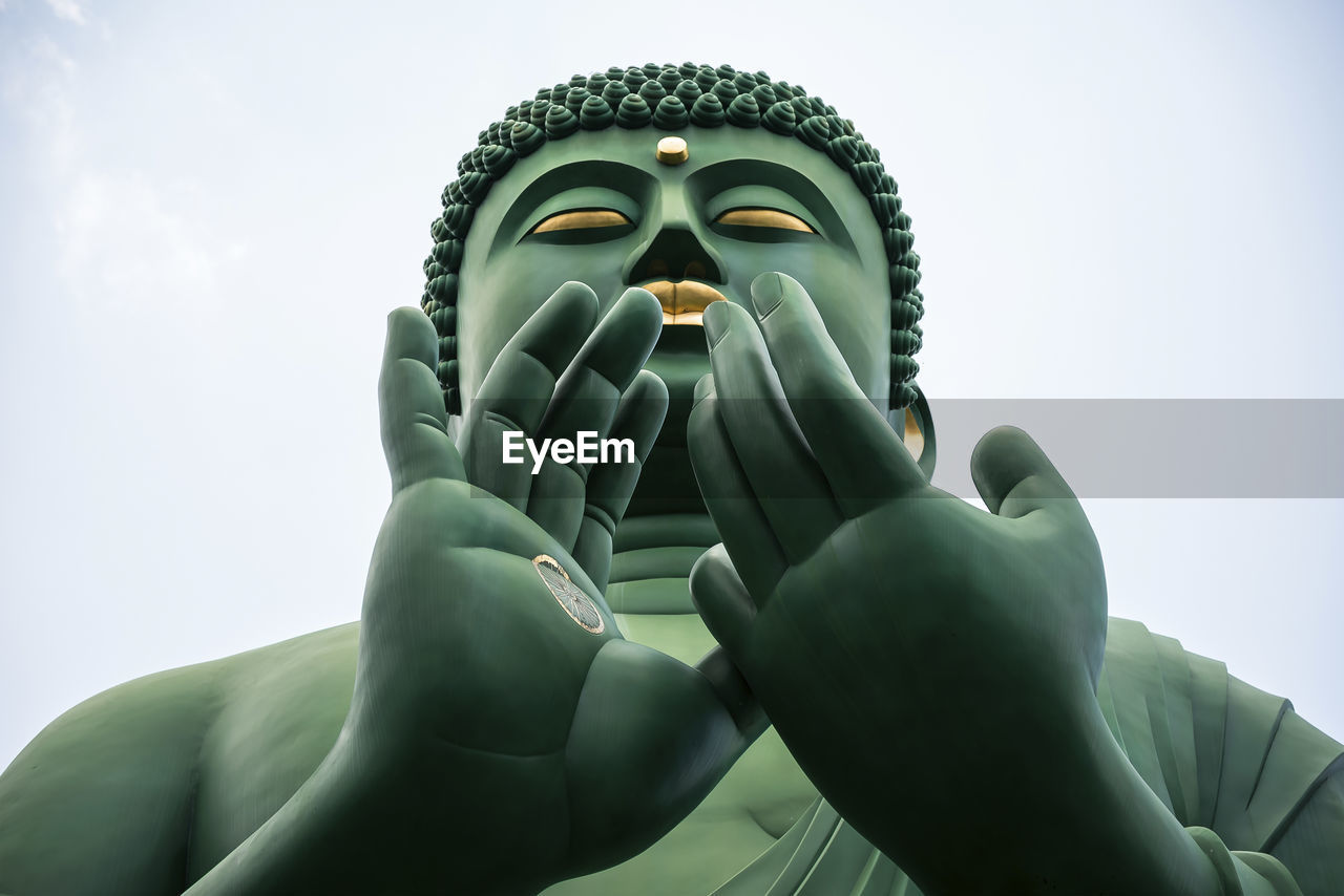 Low angle view of buddha statue against clear sky