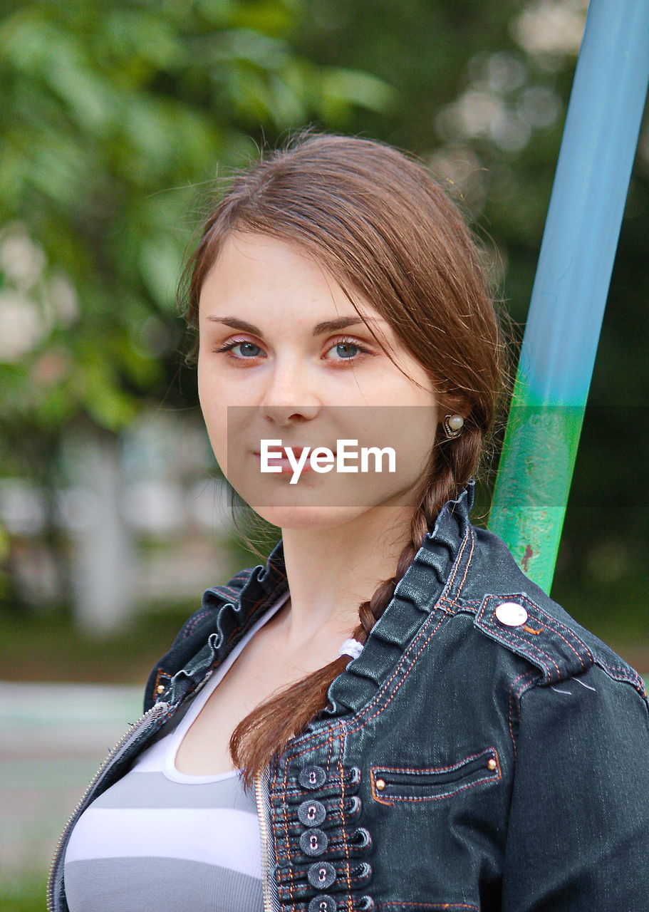 Portrait of beautiful woman with braided hair standing at playground