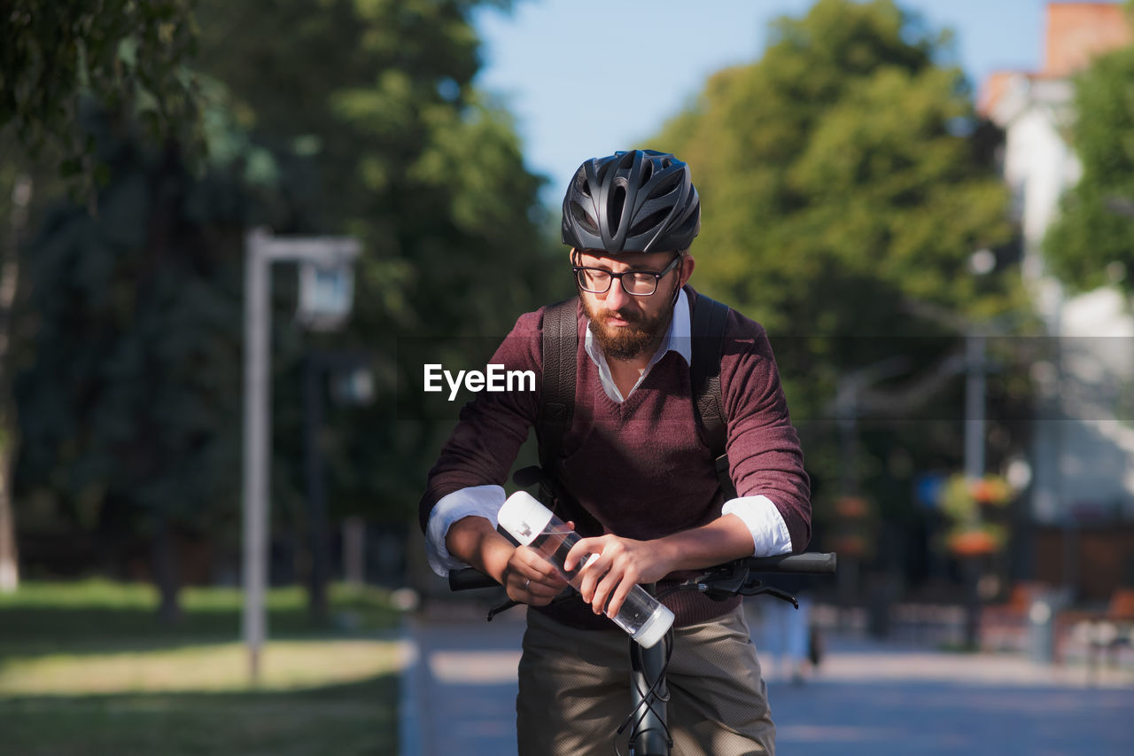 Male bike commuter with a water bottle. safe cycling in city, bicycle commuting