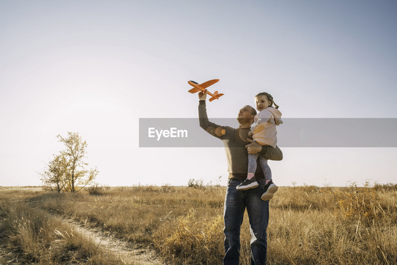 Father and child having fun outdoors. dad and daughter together, let an airplane into the sky