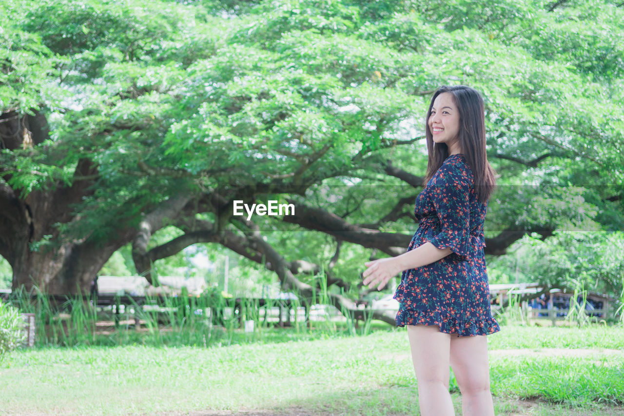 Smiling woman standing in park