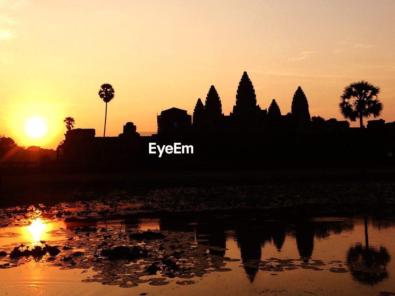 SILHOUETTE TEMPLE BY LAKE DURING SUNSET