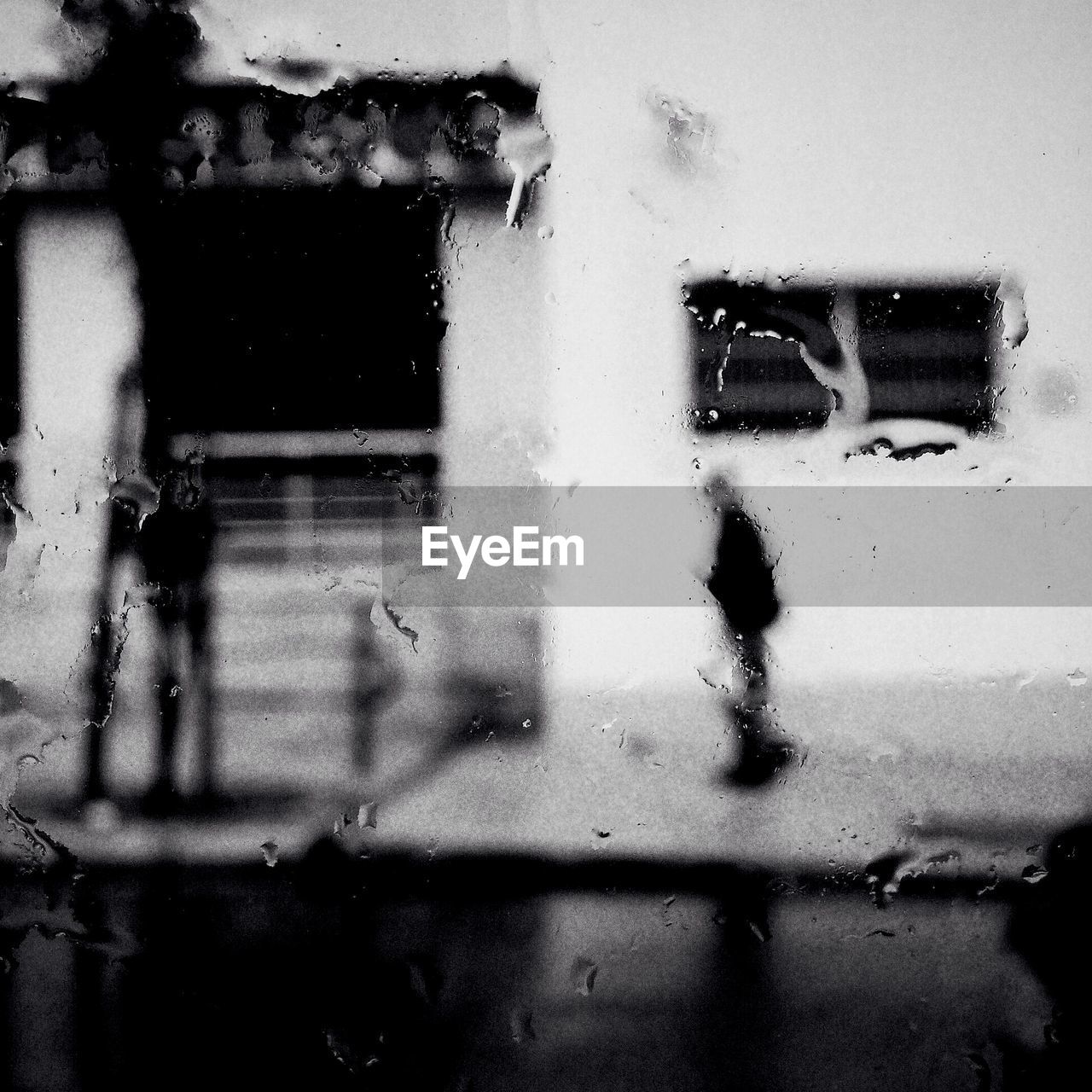 Slippery street and building seen through wet glass