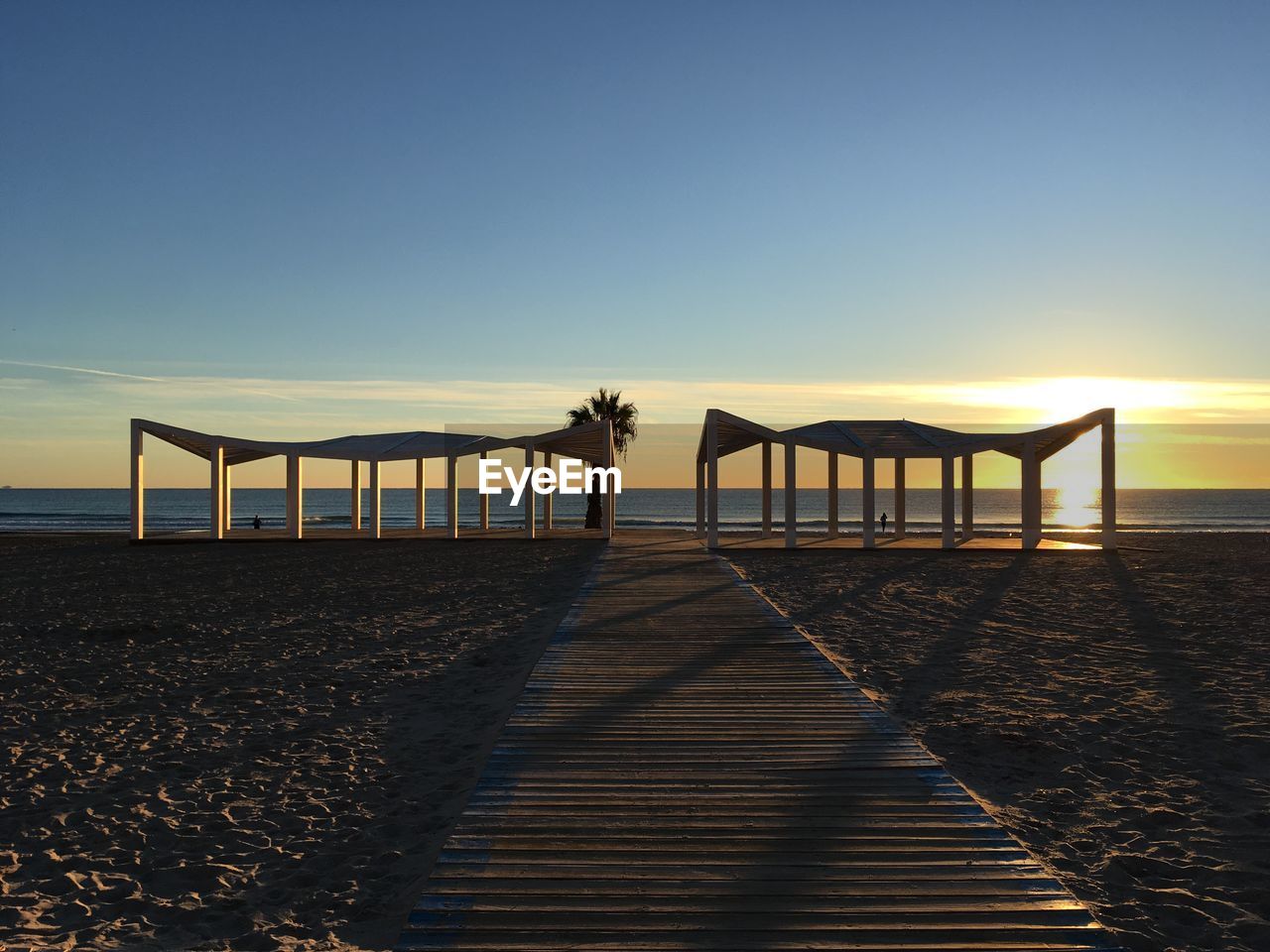 Scenic view of beach against clear sky during sunset