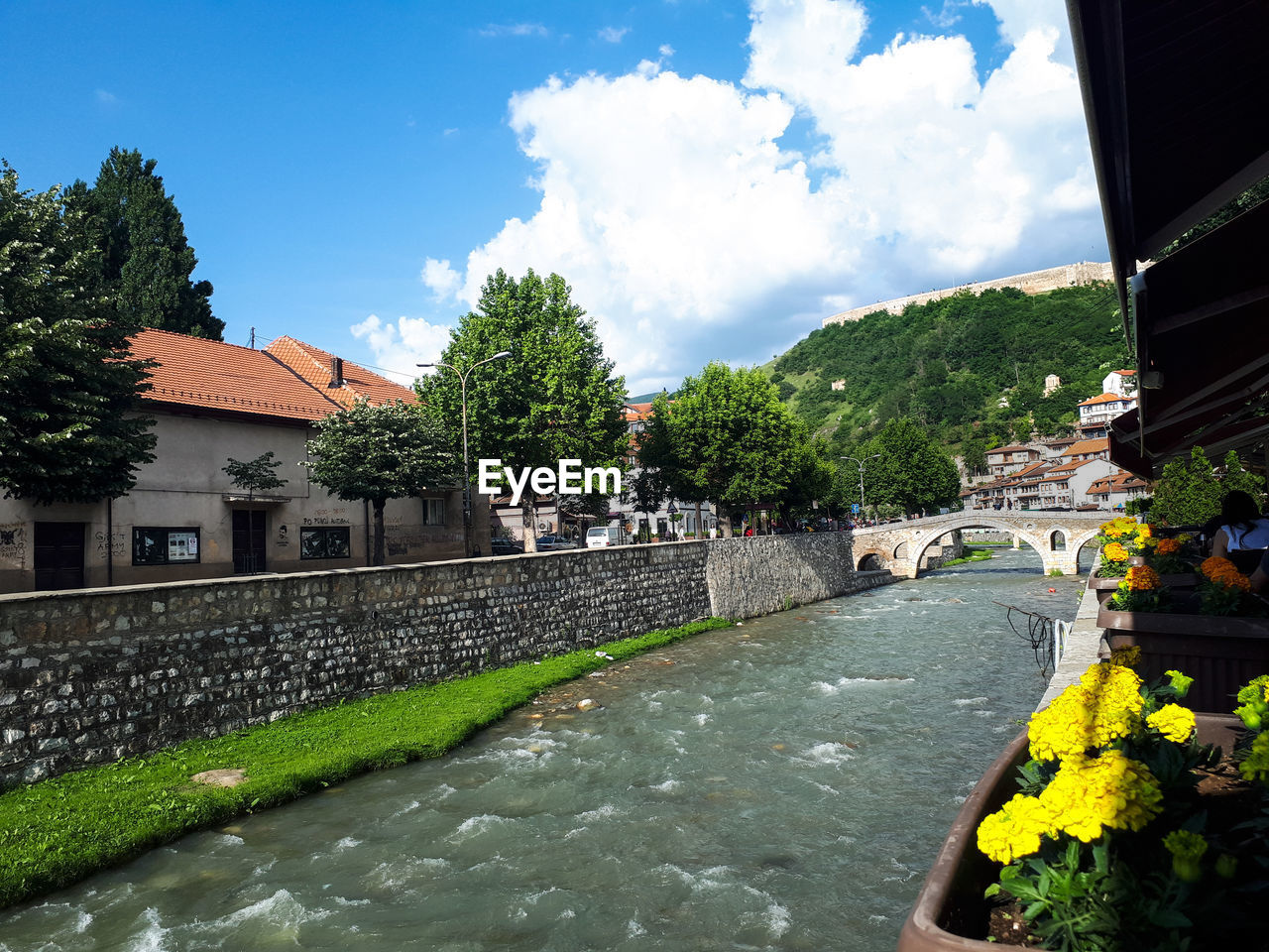 Scenic view of river amidst buildings against sky