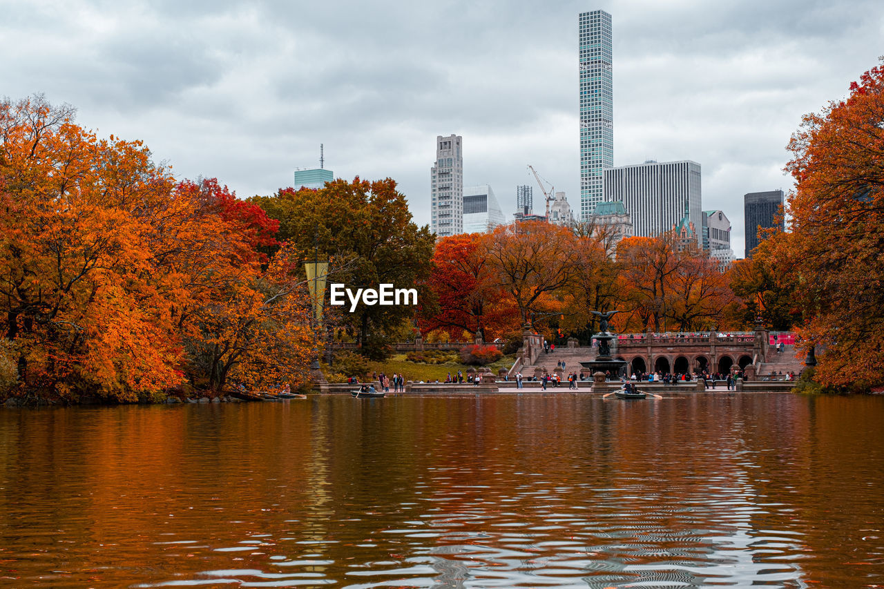SCENIC VIEW OF RIVER BY TREES AGAINST BUILDINGS DURING AUTUMN