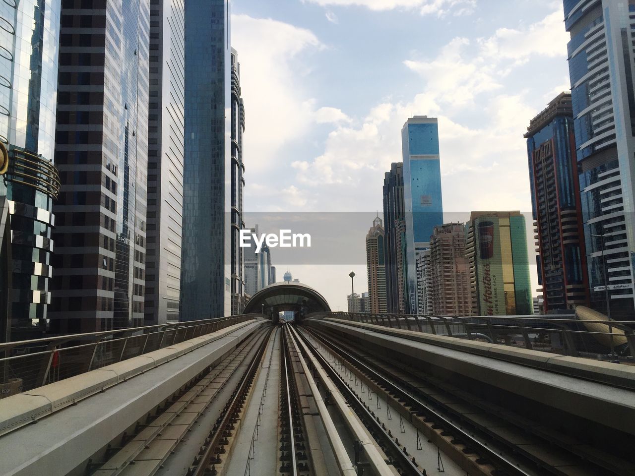 Railway bridge amidst modern buildings in city