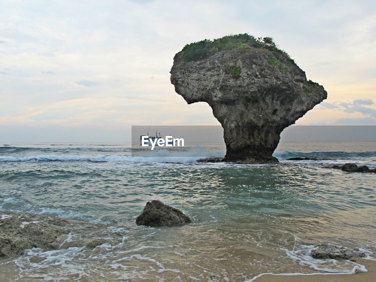 ROCK FORMATION ON SEA AGAINST SKY