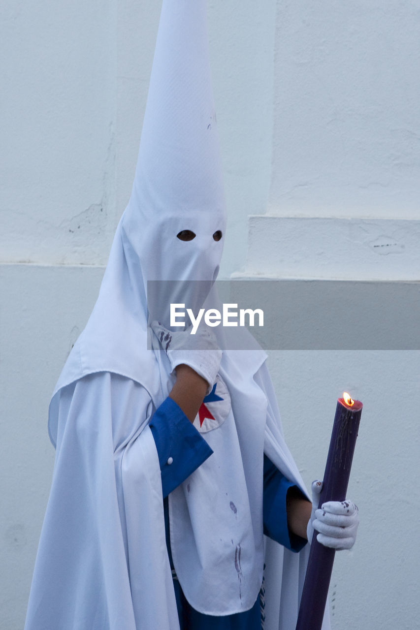 Man wearing traditional clothing against wall