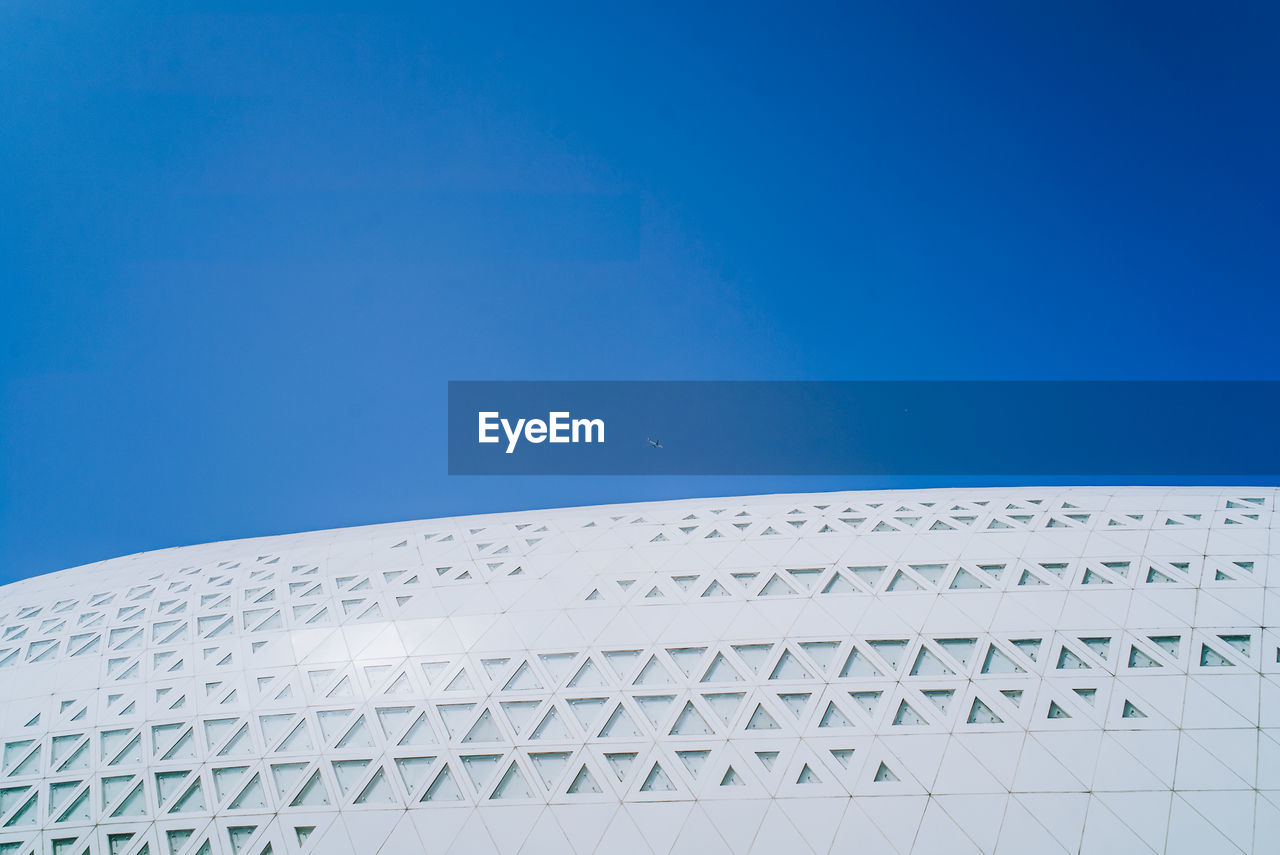 LOW ANGLE VIEW OF MODERN BUILDING AGAINST CLEAR BLUE SKY