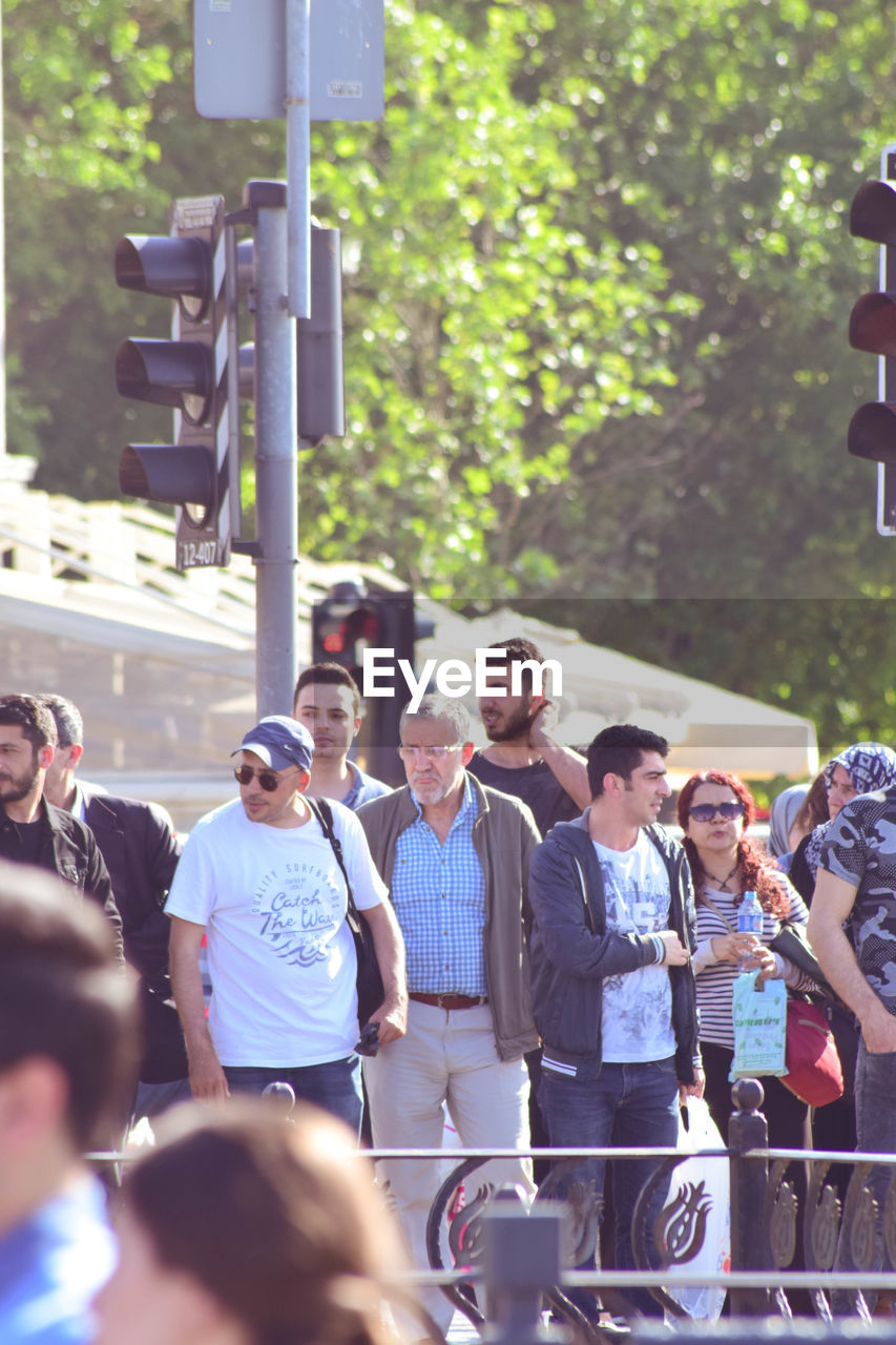 GROUP OF PEOPLE STANDING IN FRONT OF STREET