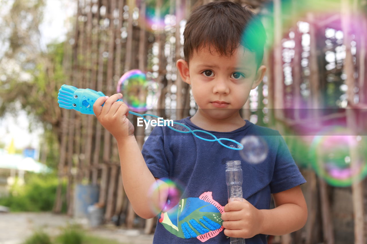 Portrait of cute boy holding bubbles