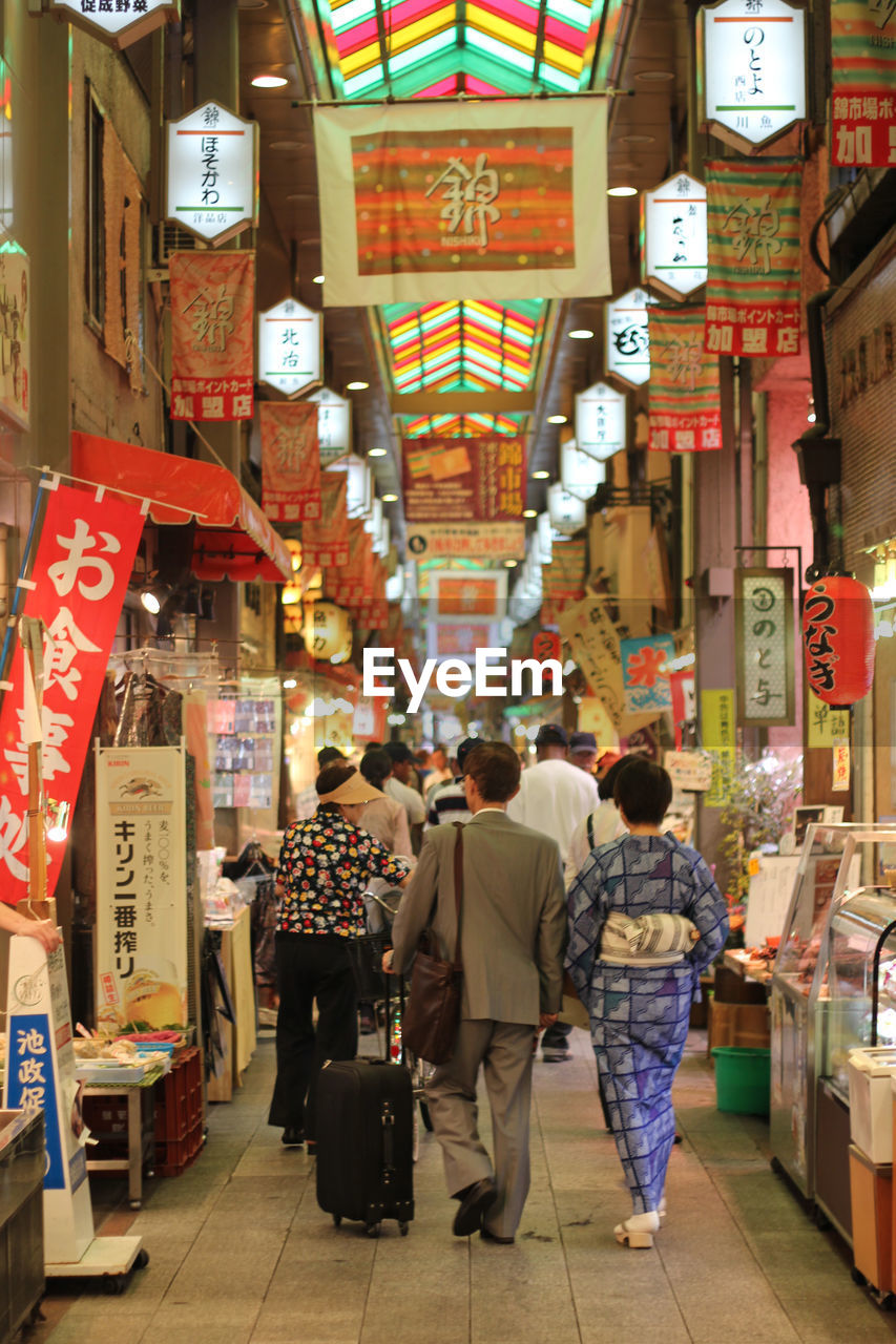 Rear view of people on street market