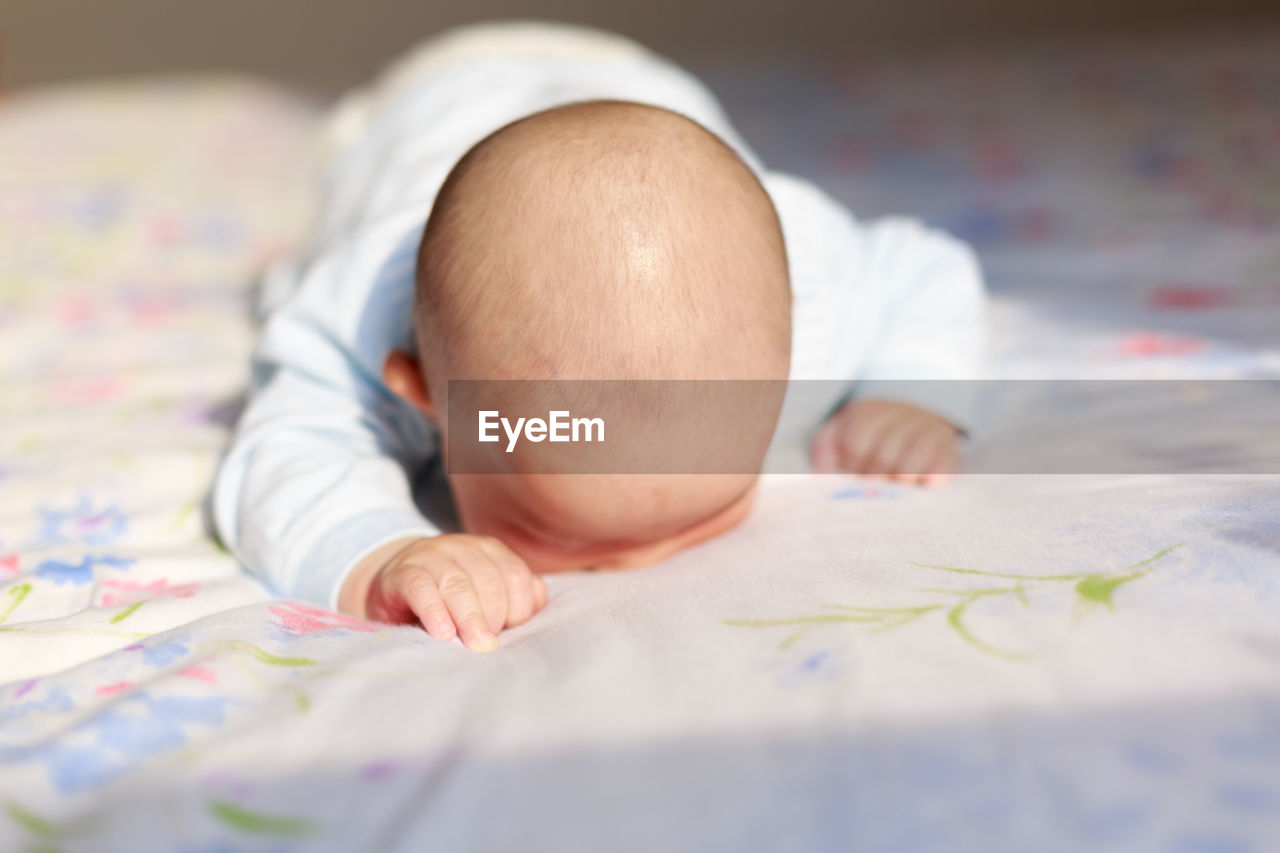 Cute baby lying on bed at home