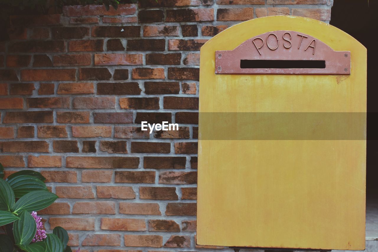 Close-up of mailbox on brick wall