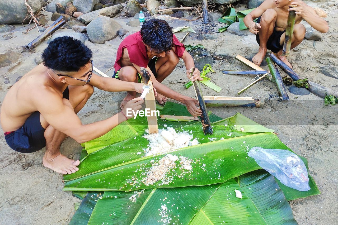 HIGH ANGLE VIEW OF PEOPLE HOLDING WET LEAVES
