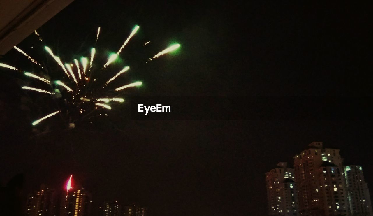 LOW ANGLE VIEW OF FIREWORKS AT NIGHT