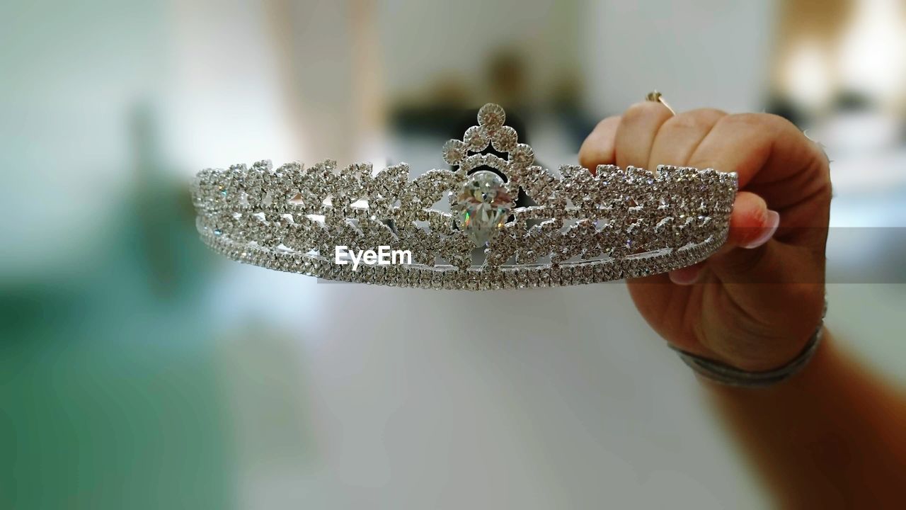 Cropped hand of woman holding crown