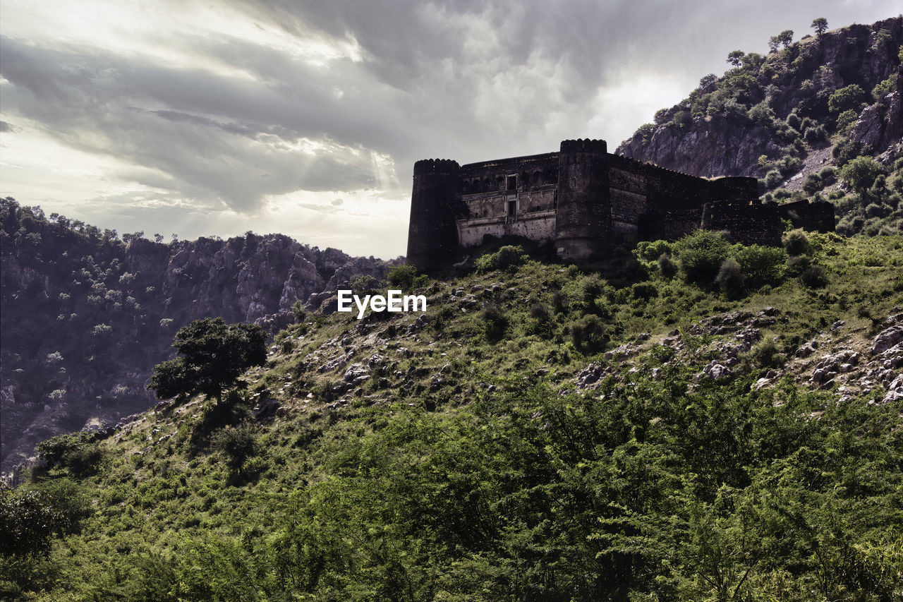 Mountains surrounding abandoned ruined fort in a place named ajabgarh on a way to bhangarh