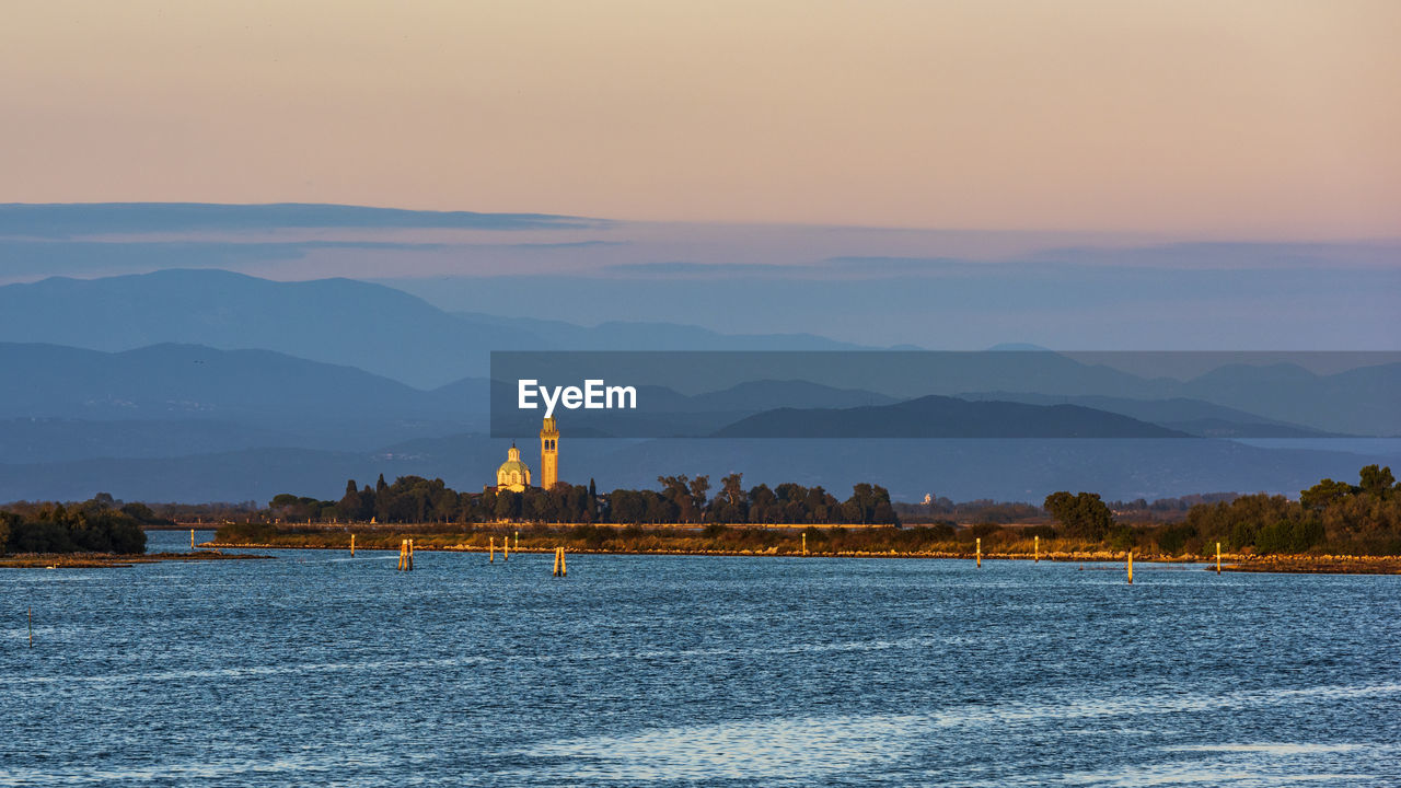 Sunset on the grado marano lagoon and a glimpse of the island of barbana.