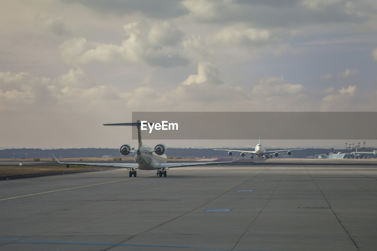 Airplane on runway against sky