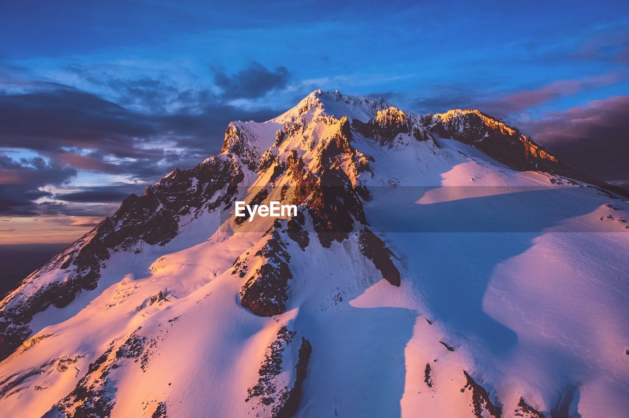 Scenic view of snow covered mt hood against sky at sunset