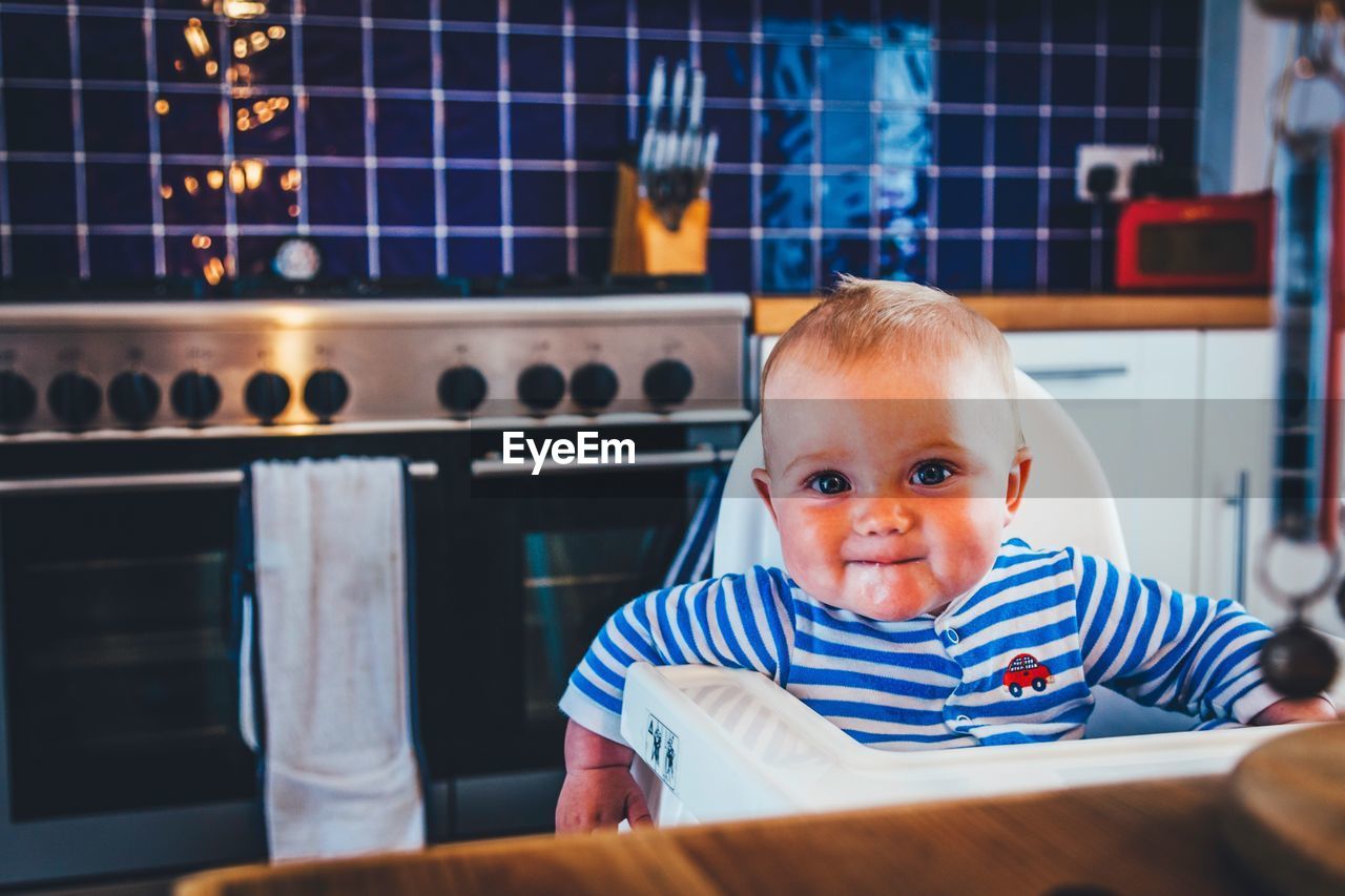 Portrait of cute boy sitting at home