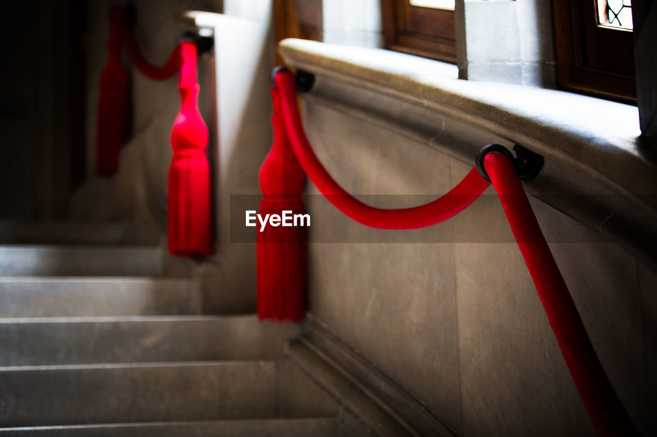 Red decorations hanging by steps in building