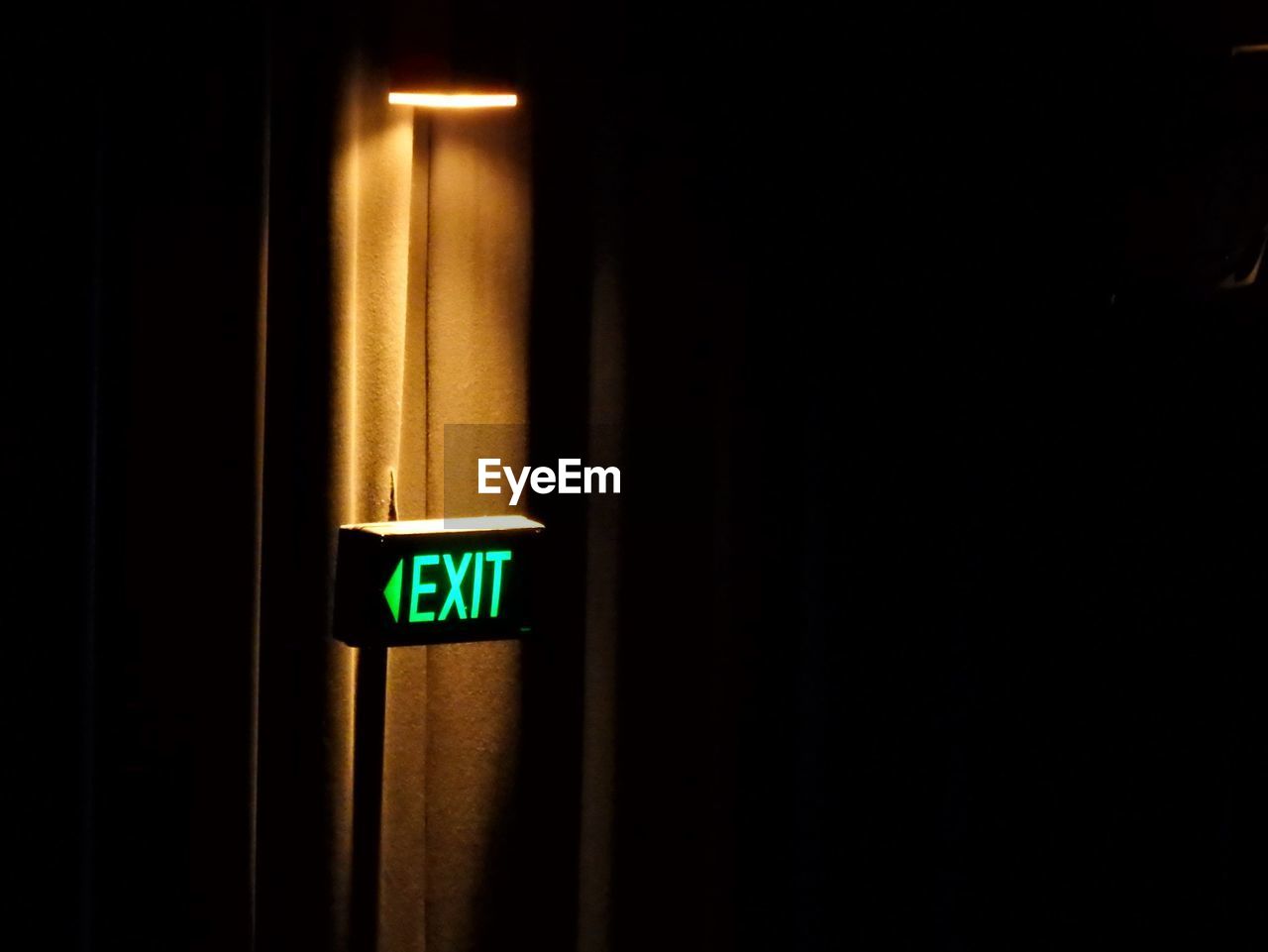 Illuminated exit sign on doorway in movie theater