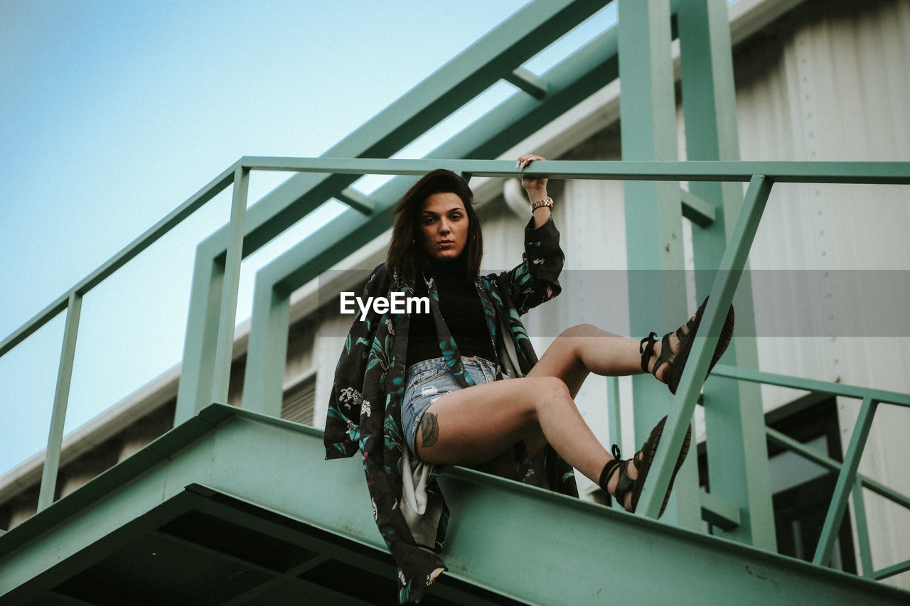 Fashionable young woman on bridge in city