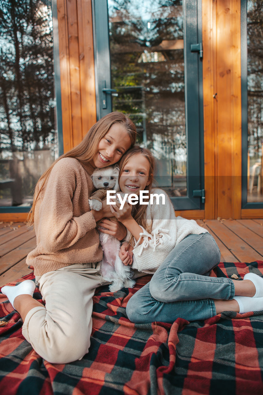 MOTHER AND DAUGHTER SITTING ON FLOOR