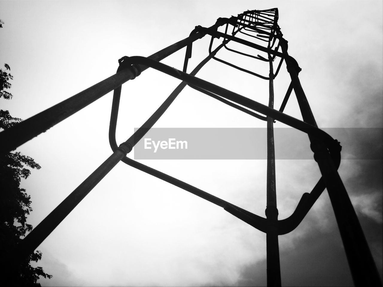 Low angle view of metallic structure against cloudy sky