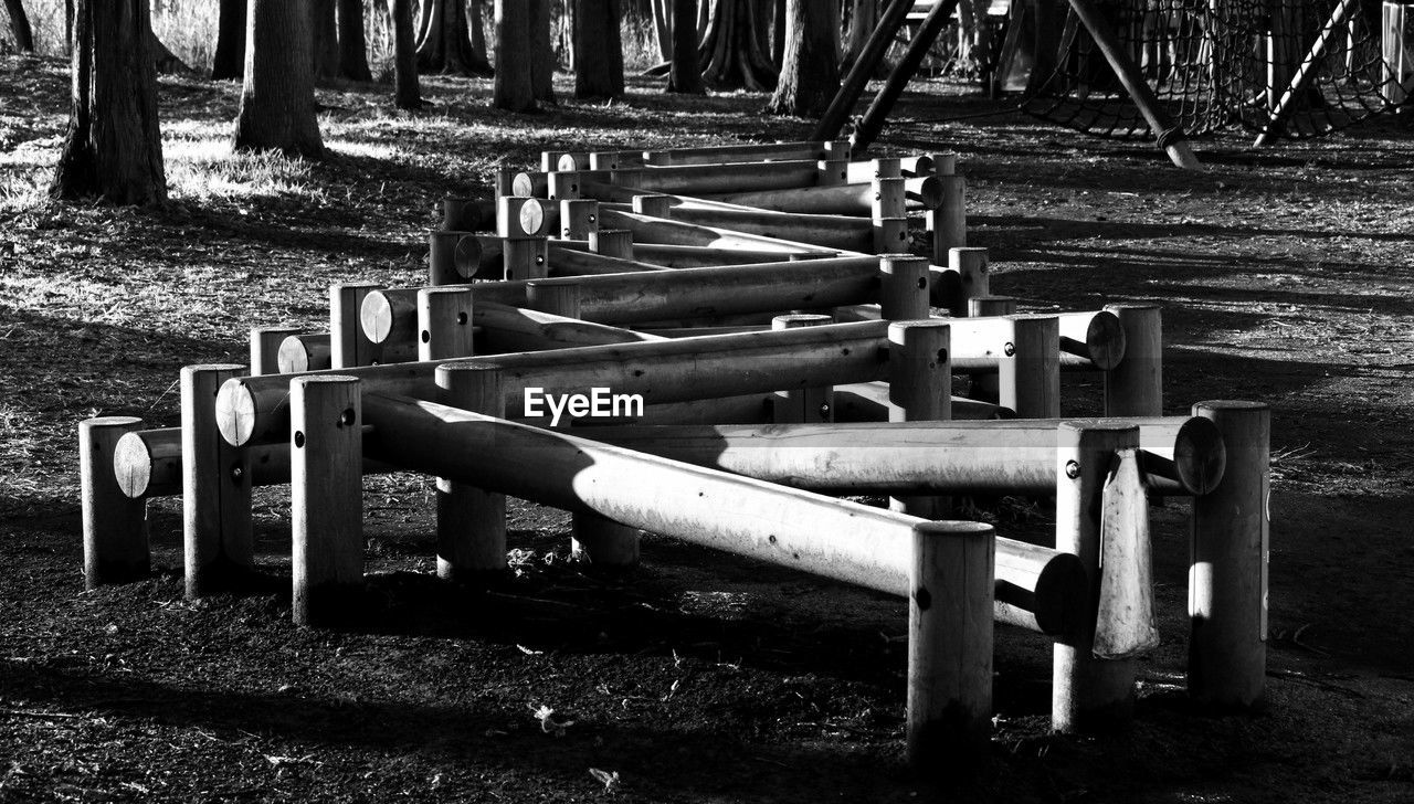 black and white, playground, monochrome photography, monochrome, black, nature, no people, day, land, tree, plant, seat, park, wood, darkness, outdoors, field, park - man made space, furniture, sunlight, metal, white, grass, tree trunk