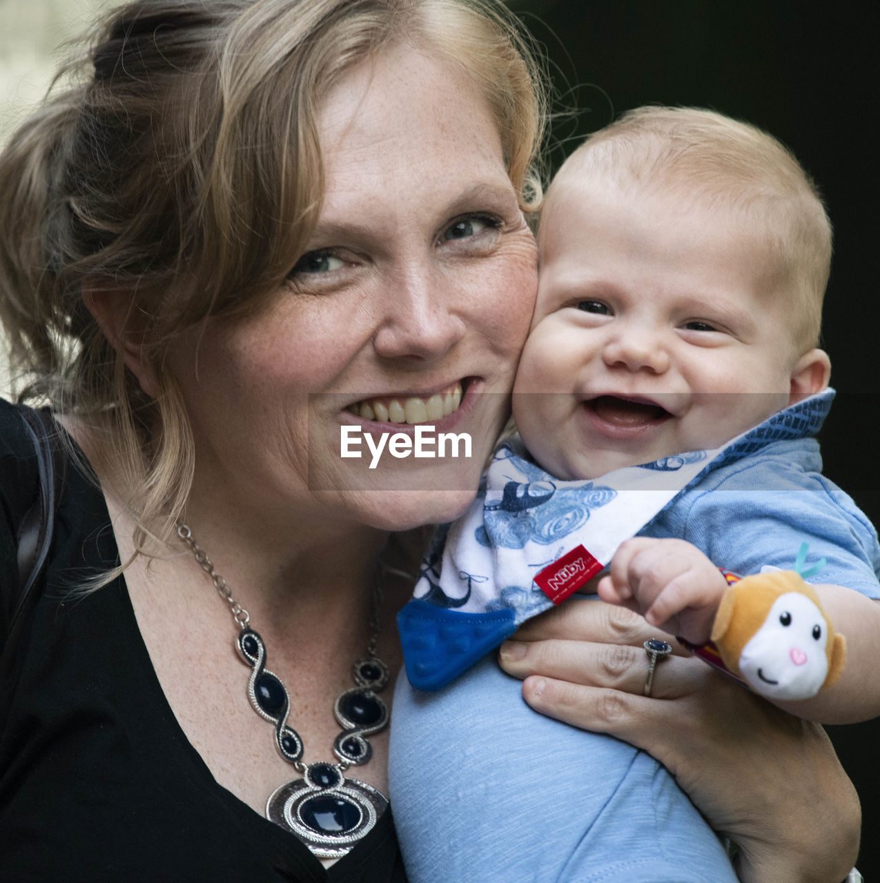 Close-up portrait of smiling mother and baby boy