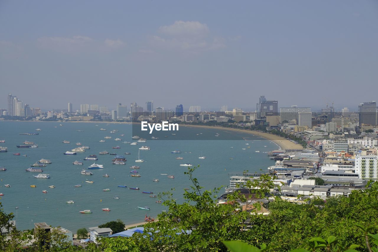 HIGH ANGLE VIEW OF SEA AND BUILDINGS IN CITY