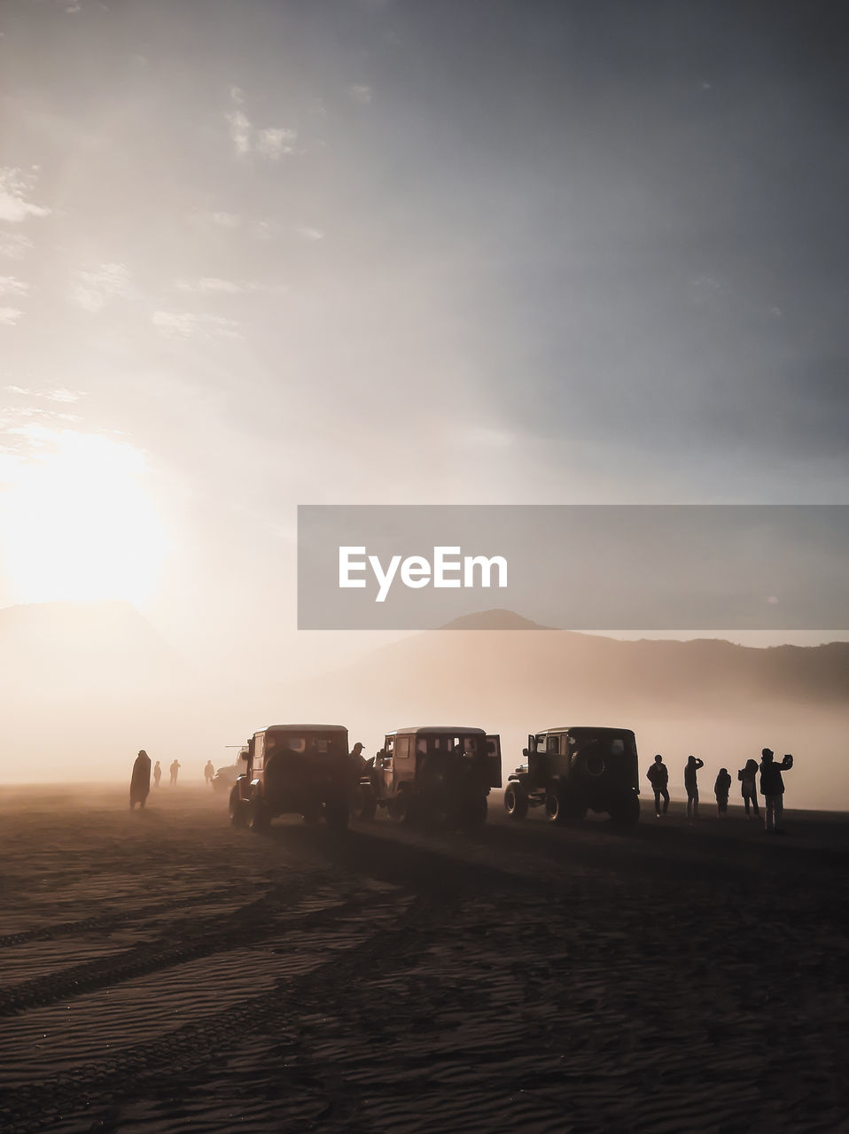 Vehicles and people standing in desert