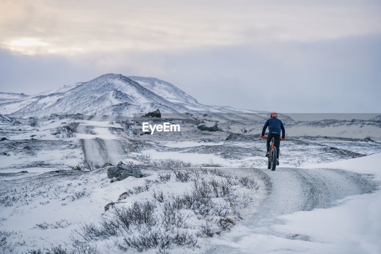 Man cycling in snow