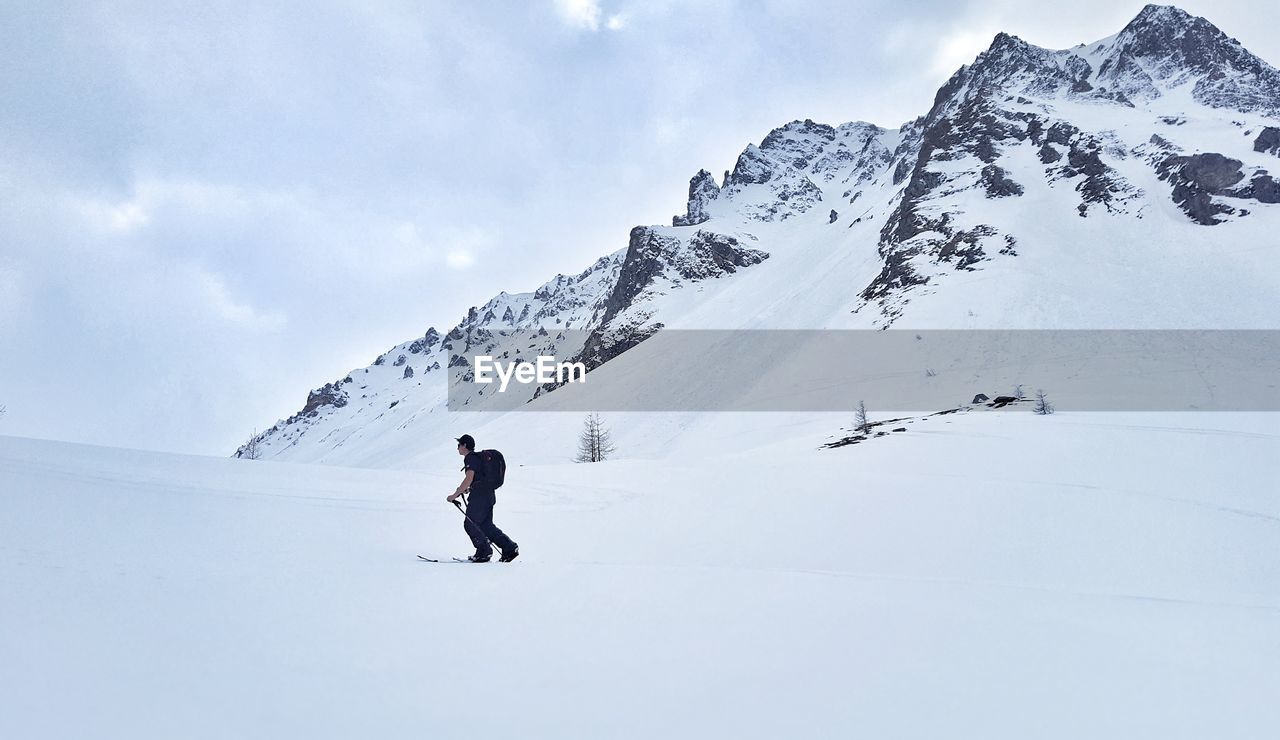 Man skiing against mountains during winter