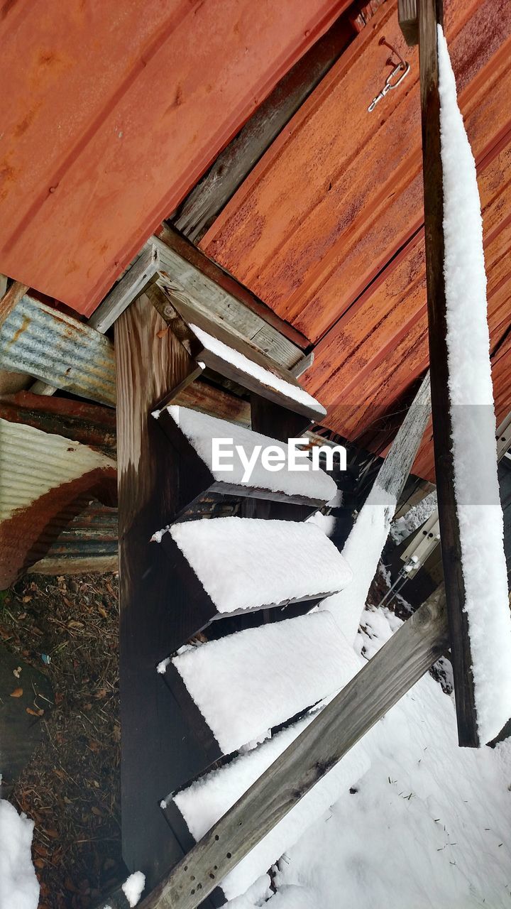 LOW ANGLE VIEW OF HOUSES IN SNOW COVERED ROOF OF BUILDING