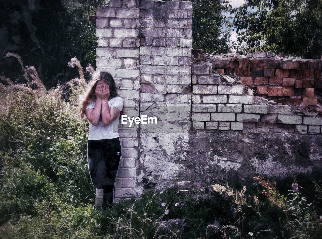 WOMAN STANDING BY WALL