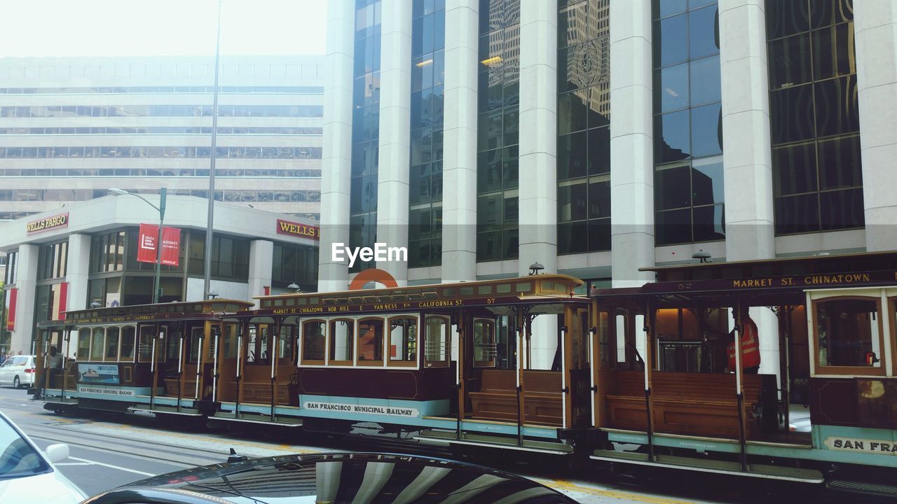 TRAIN AT RAILROAD STATION IN CITY