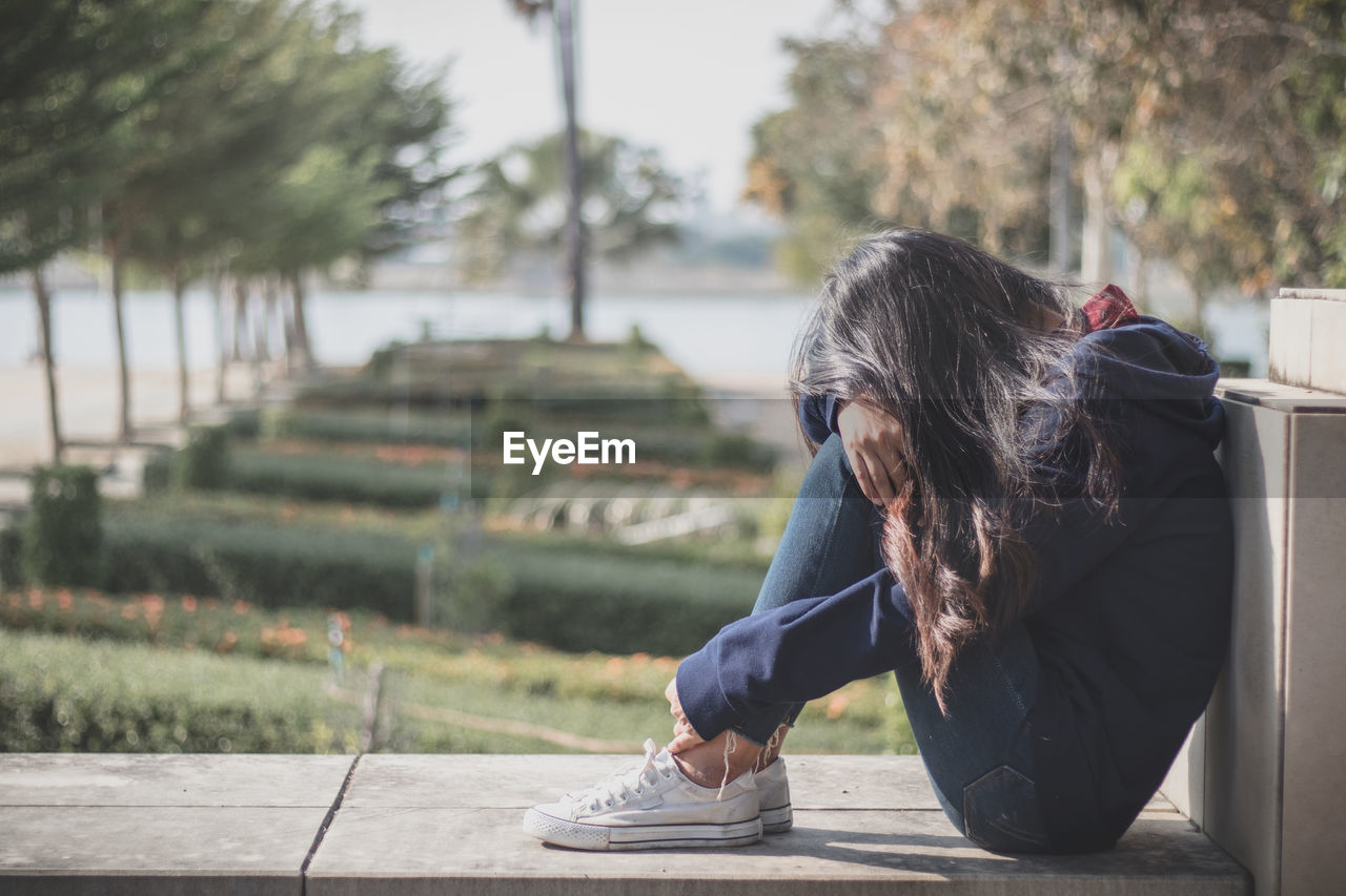 Sad woman sitting in park