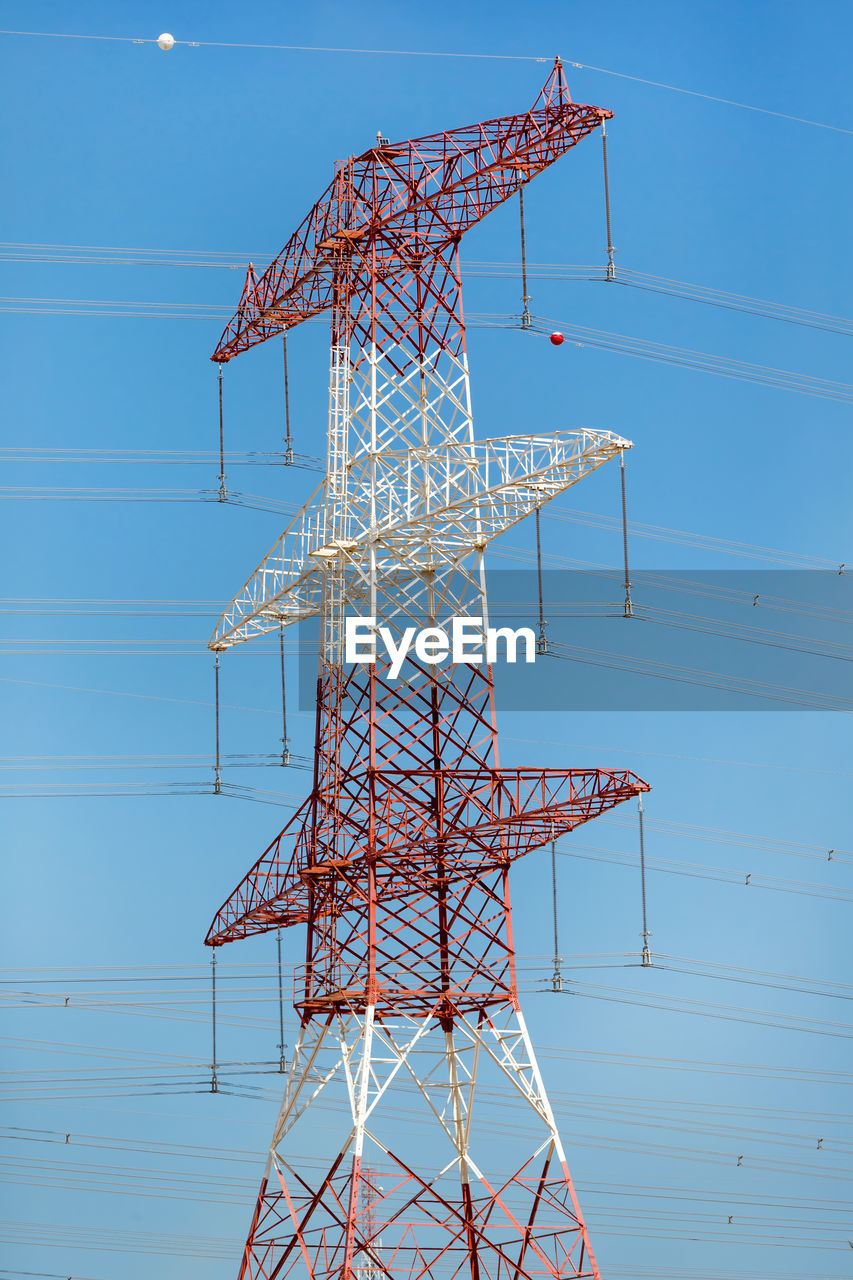 LOW ANGLE VIEW OF ELECTRICITY PYLONS AGAINST BLUE SKY